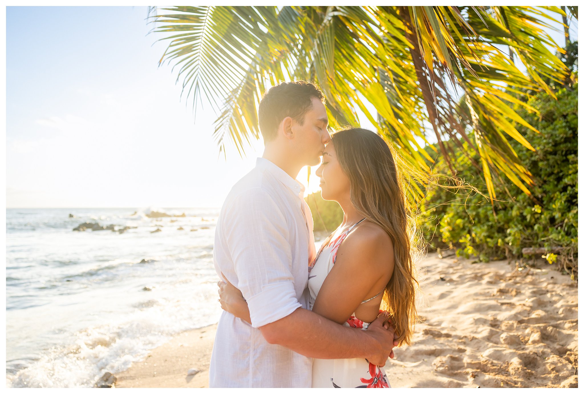 Two people pose on the beach for honeymoon portraits