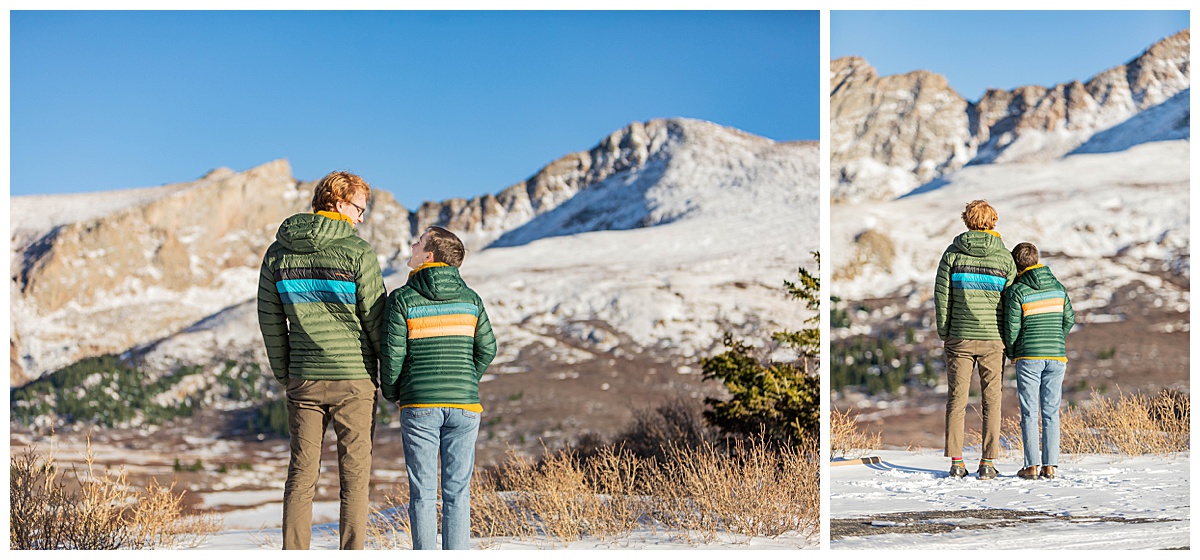 A couple poses in front of snow, mountains, and pine trees for couple portraits.