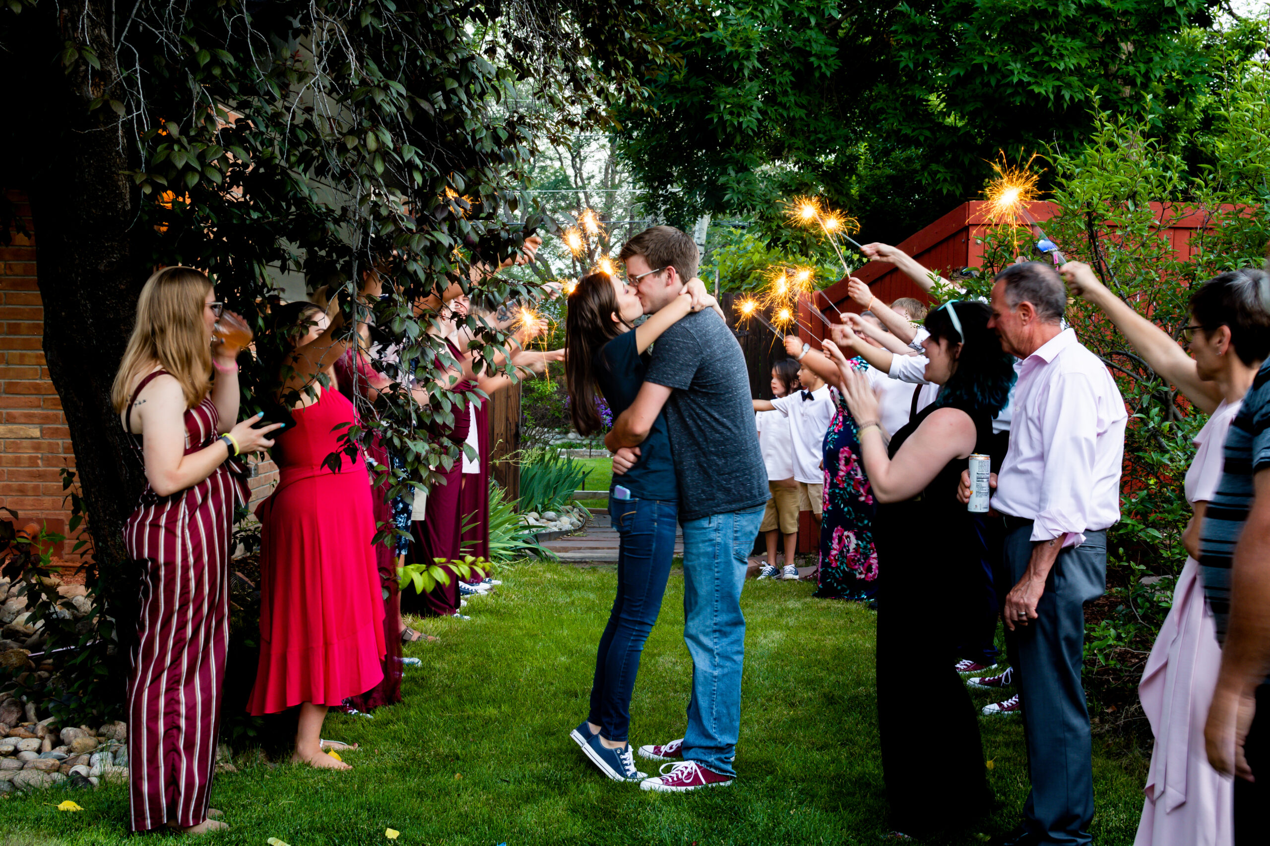 A couple leaves their wedding reception with their guests holding sparklers around them.