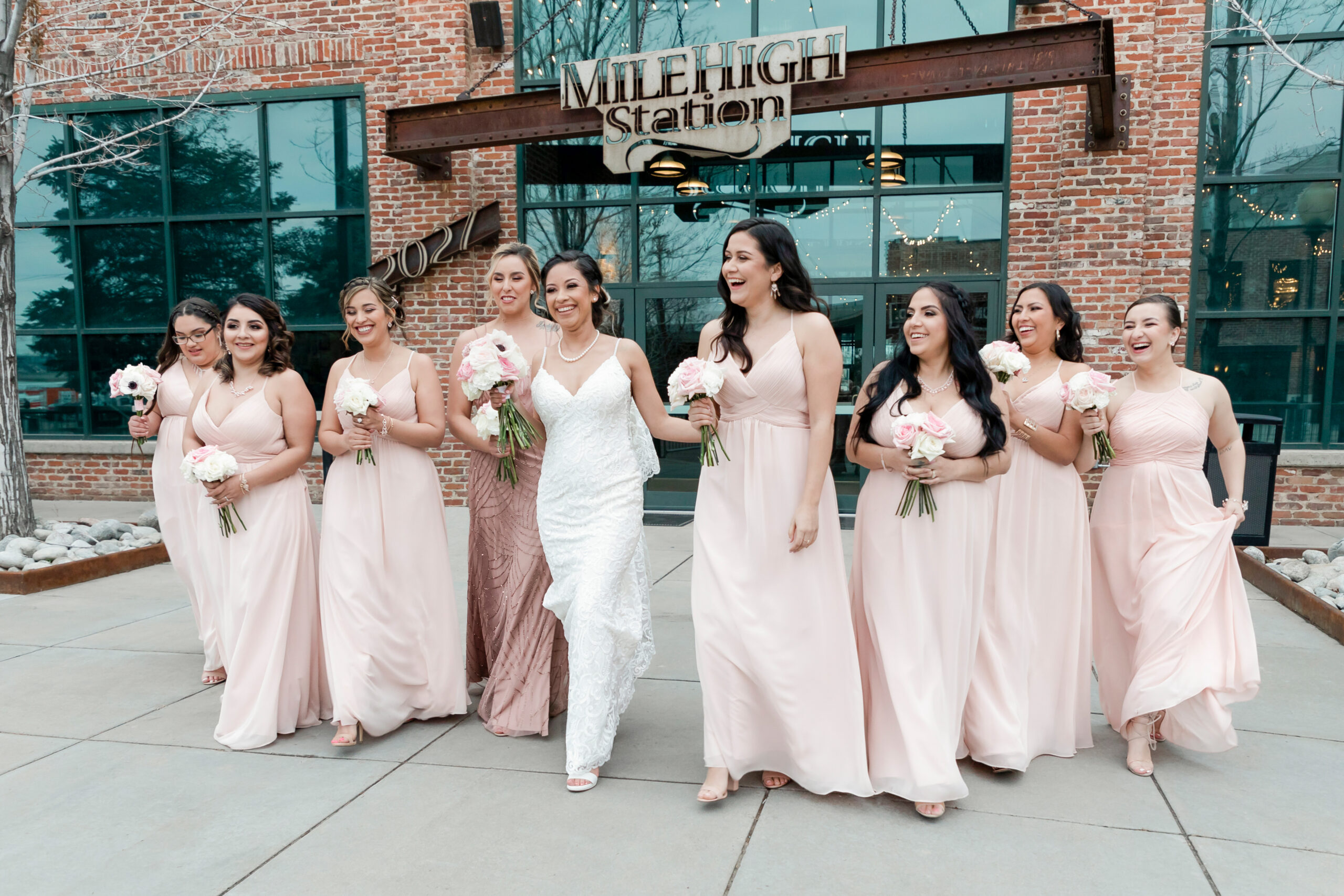 A bride walks with her bridesmaids for wedding party photos.