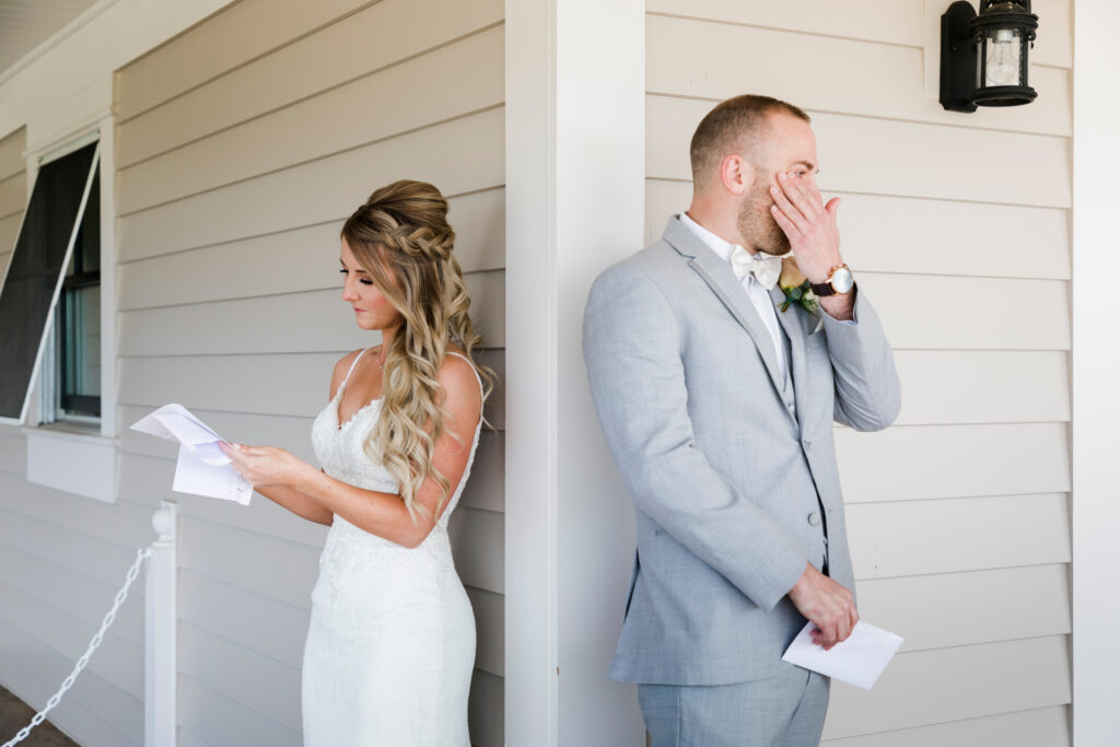 A couple reads letters to each other before their wedding day. The man is wiping a tear from his eye.