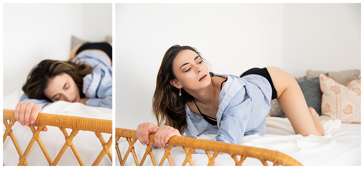 A woman poses on a bed in a light blue button-down during a boudoir session