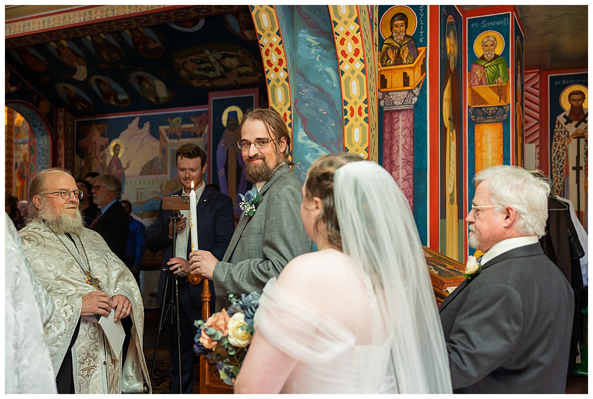The groom sees his bride for this first time at their Orthodox wedding ceremony