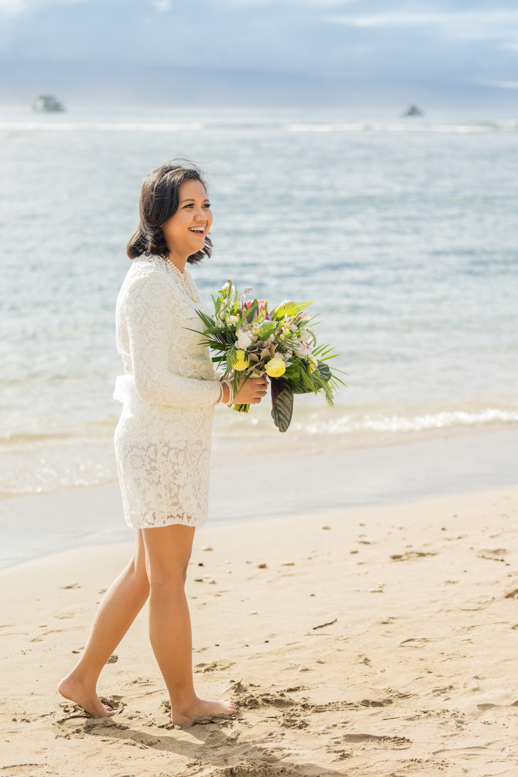 A bride sees her bride for the first time. They are getting married on the beach in front of the ocean.