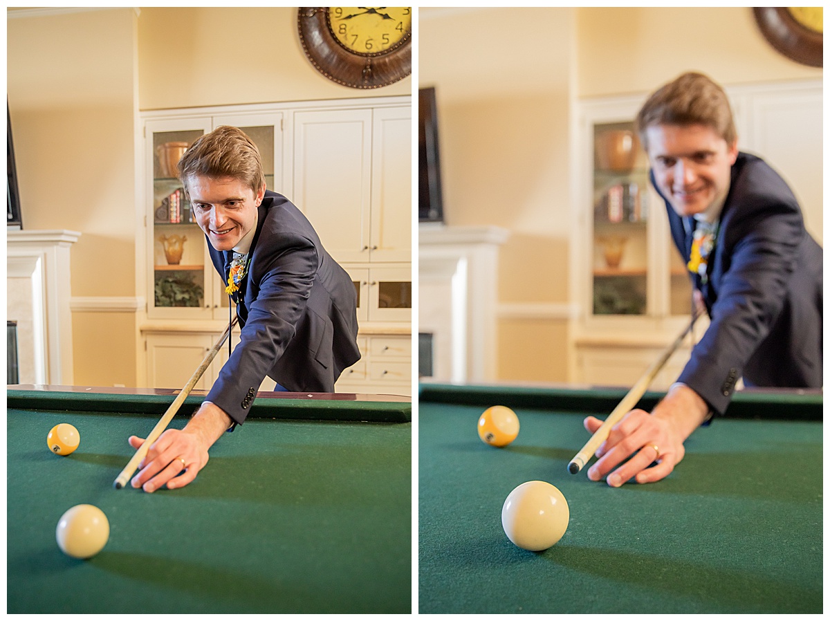 The groom poses in the groom's quarters in his blue suit shooting pool.