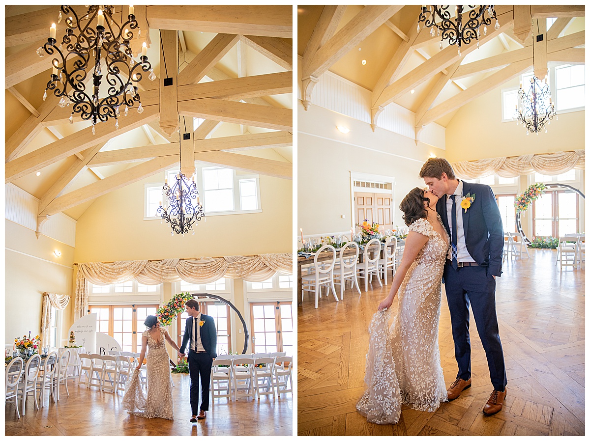 A bride and groom pose in front of a wedding arch and chairs under a chandelier.