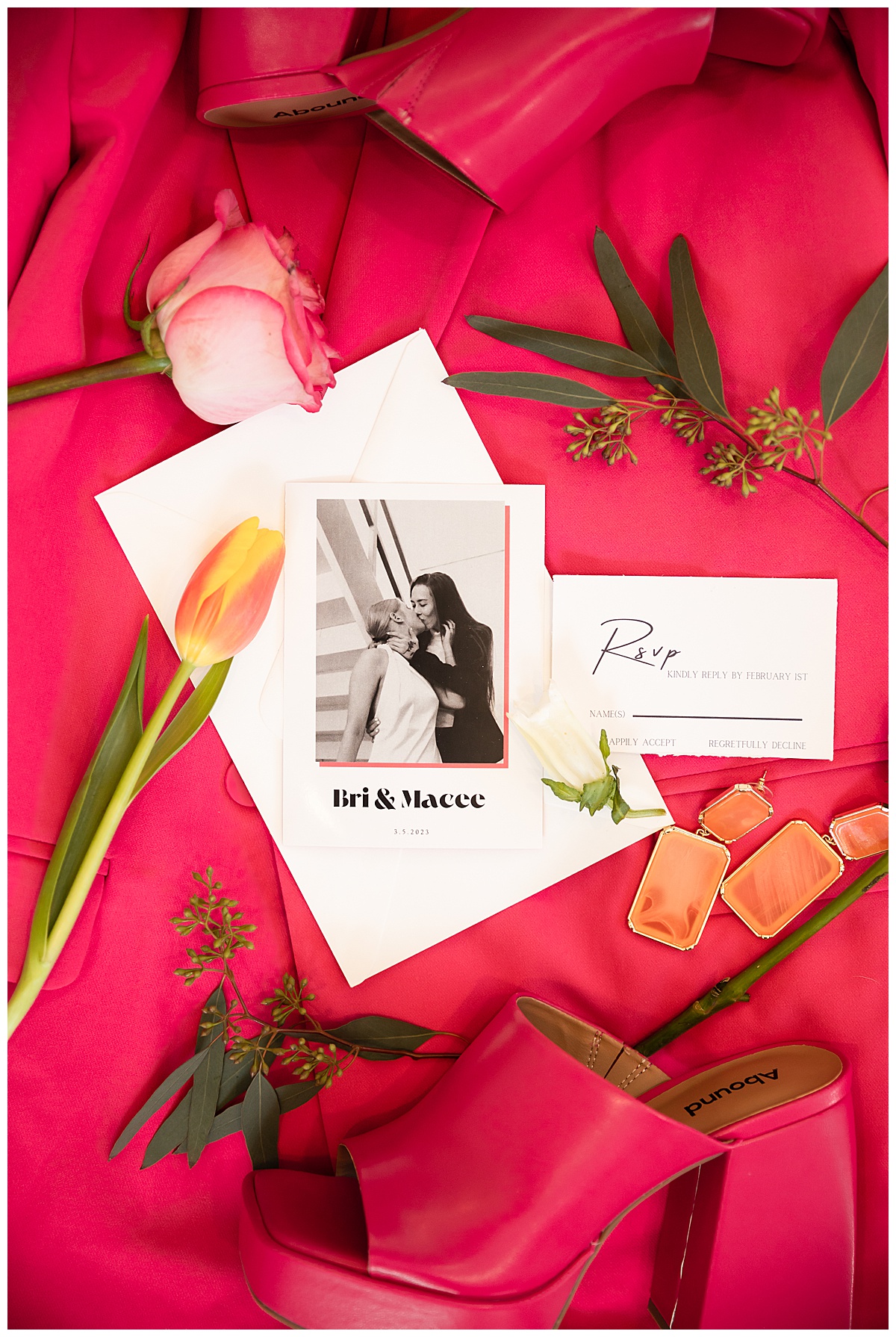 A bright pink flat lay with an invitation, flower cuttings, jewelry, and shoes is the perfect companion to this summer wedding inspiration photo shoot.