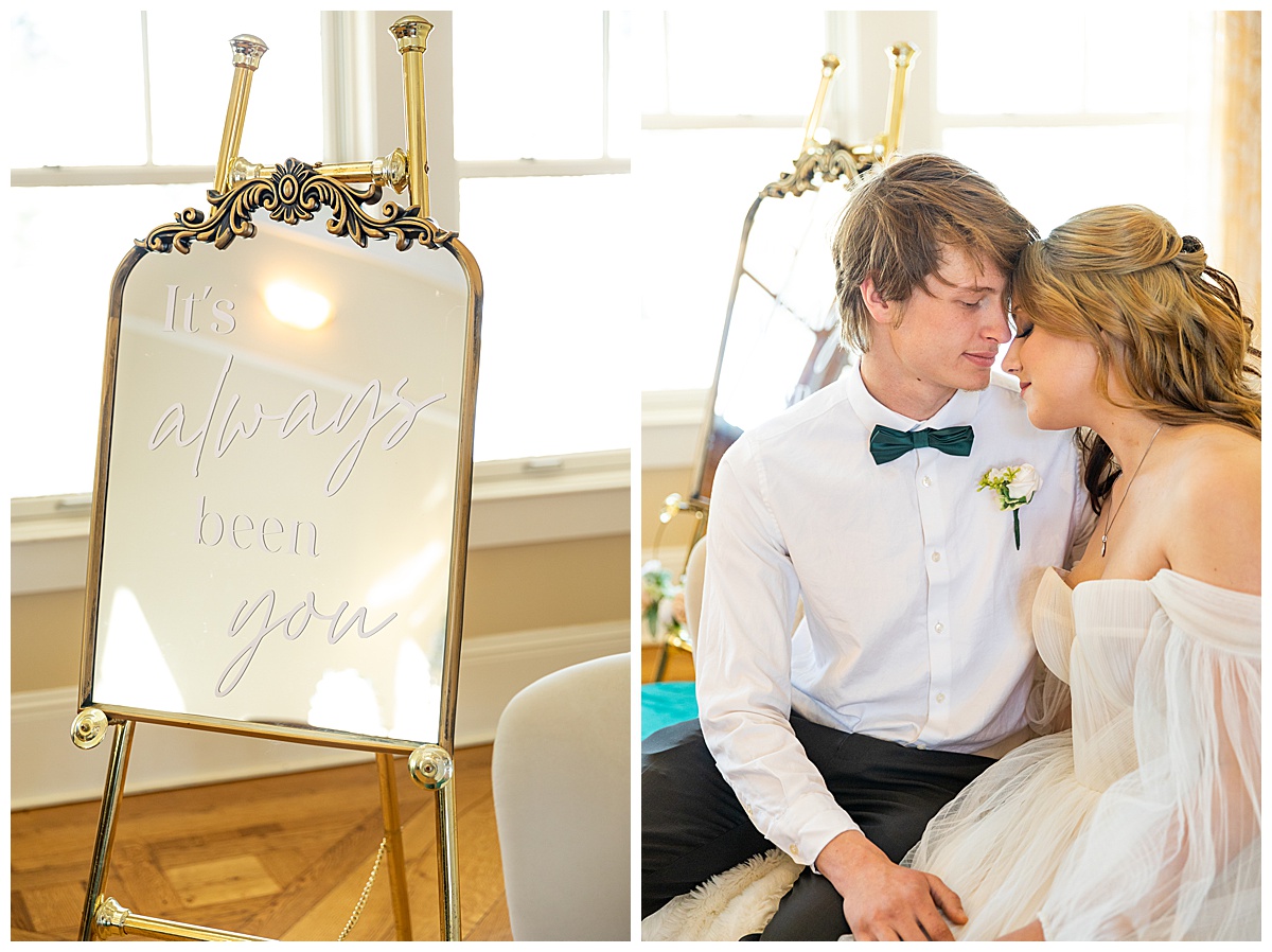 A man and woman cuddle on a couch next to a gold mirror with the words "It's always been you" on the mirror.