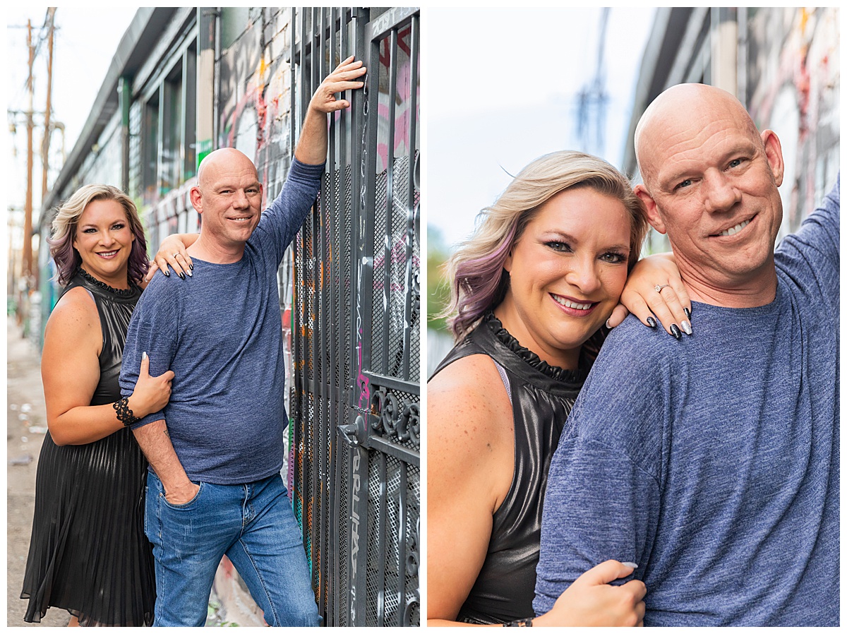 A woman with blonde hair dark silver dress and a bald man in a blue sweater pose in front of a mural in downtown Denver, Colorado