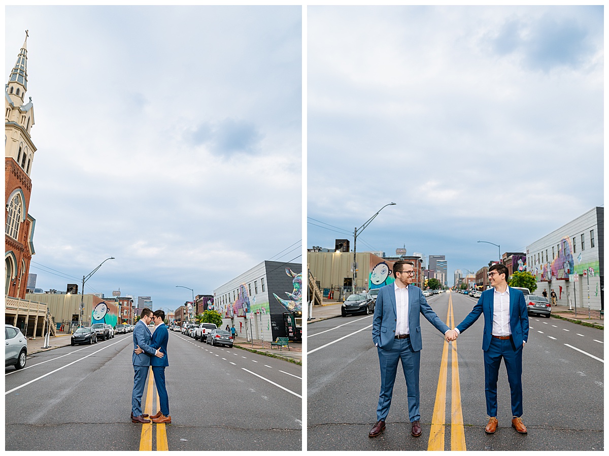 Two men pose in the middle of a downtown street dressed in blue suits