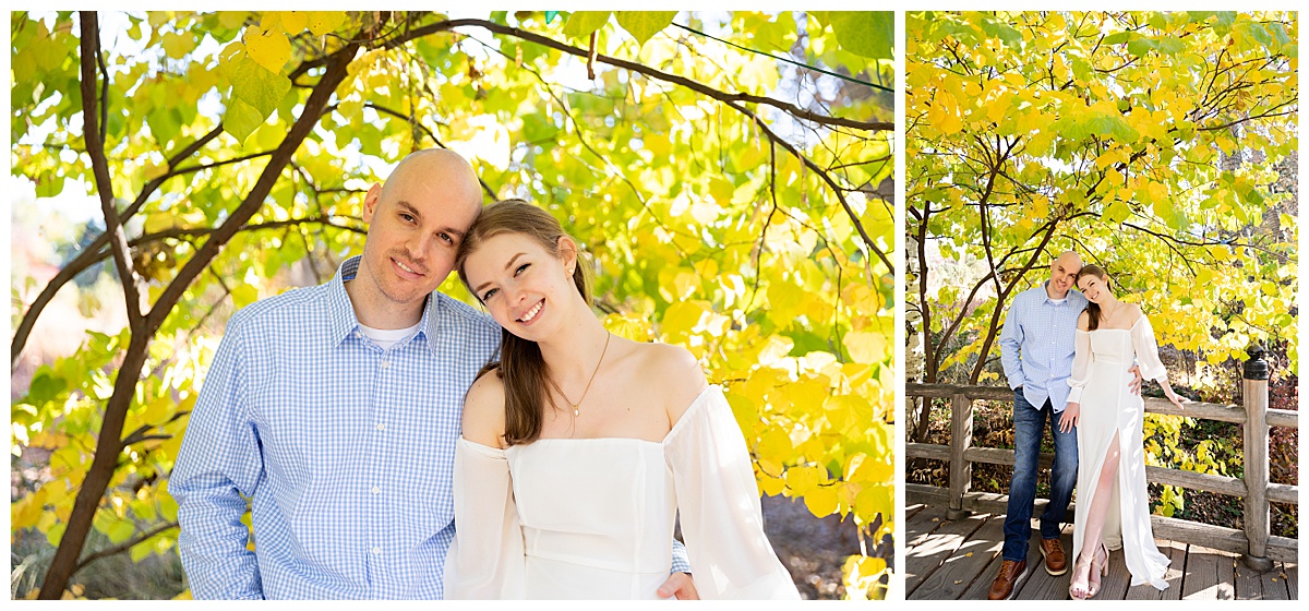 A couple poses during their botanic gardens engagement session. The blonde woman is wearing a white long sleeve dress and the bald man is wearing a blue plaid shirt and jeans.