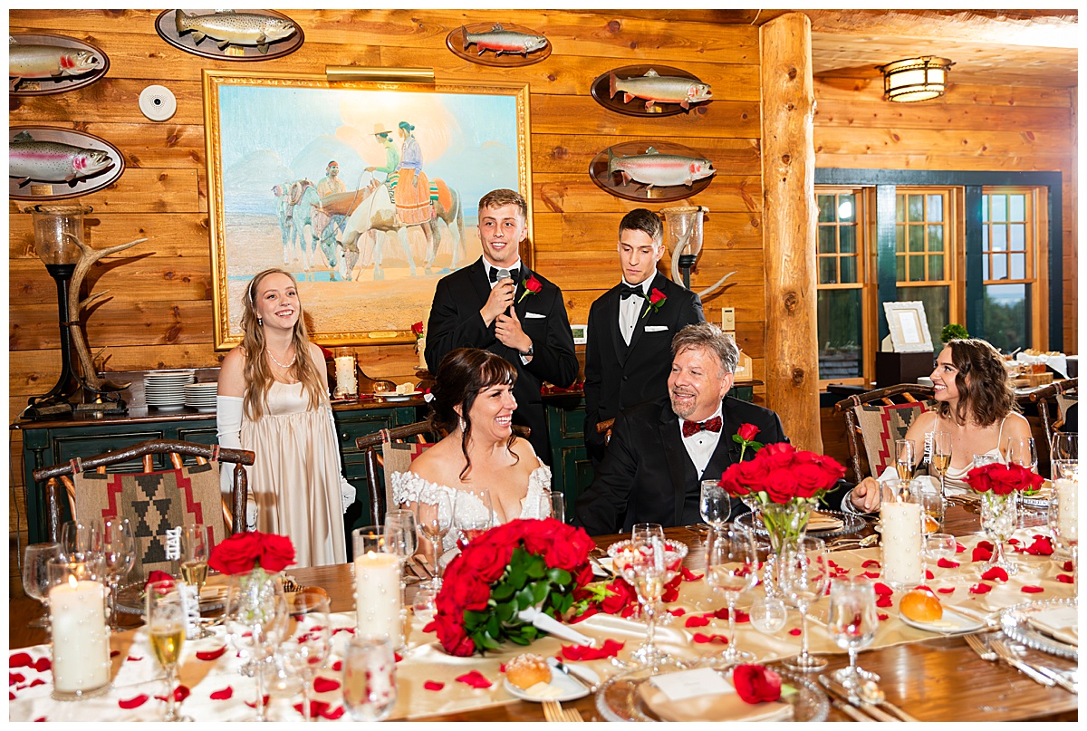 The family and bride & groom sit around the long table to do toasts