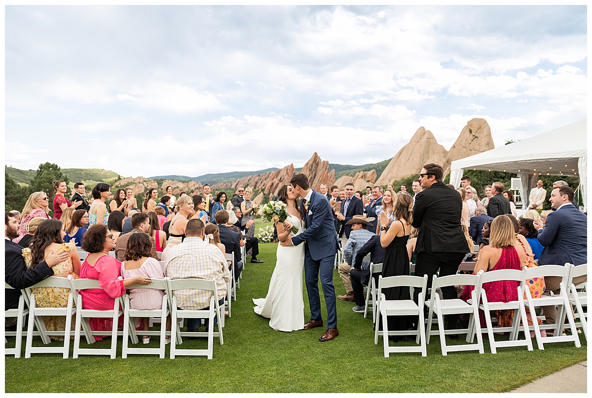 The couple walk down the aisle and kiss after their wedding ceremony