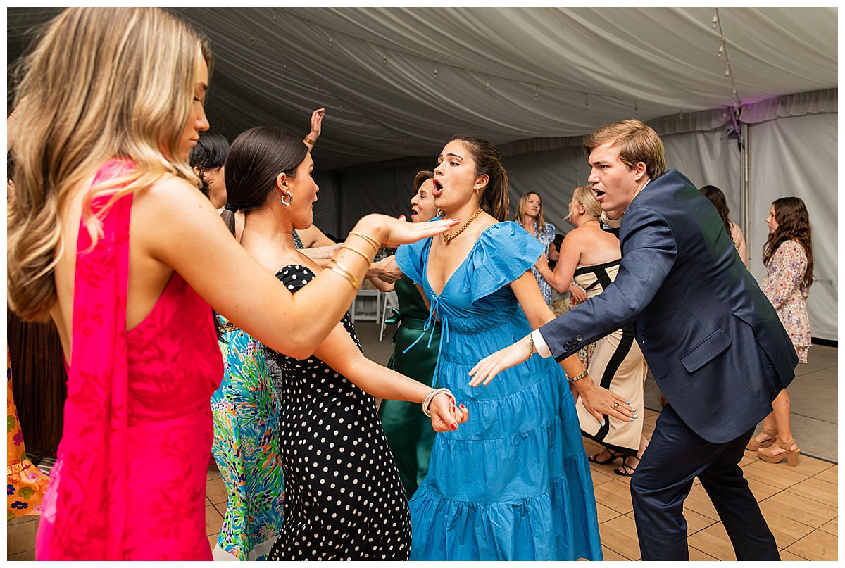 The bride, groom, and guests party during the reception. They are dancing on the dance floor, laughing, and posing for the camera.