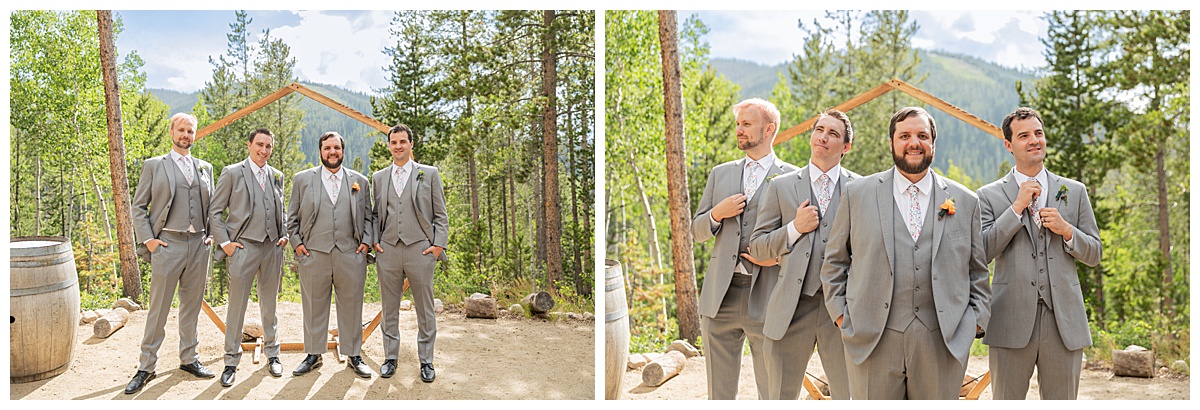 The groom and groomsmen are posing for photos. The men are wearing gray suits. Pine trees and a mountain are behind them.