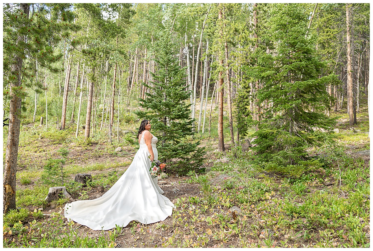 The bride takes solo photos. Her dress is white and lace on the top and a simple a-line skirt.