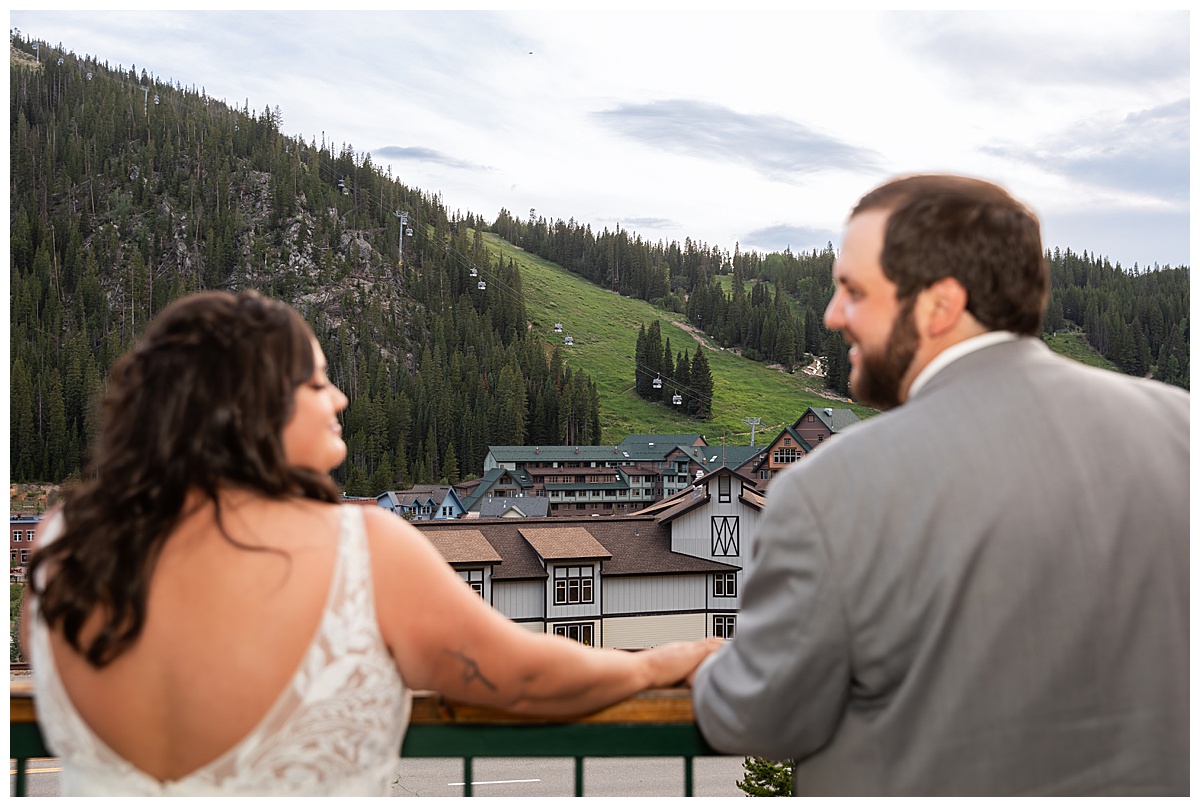 The bride and groom look out over the gondola and ski town of Winter Park together as the sun sets.