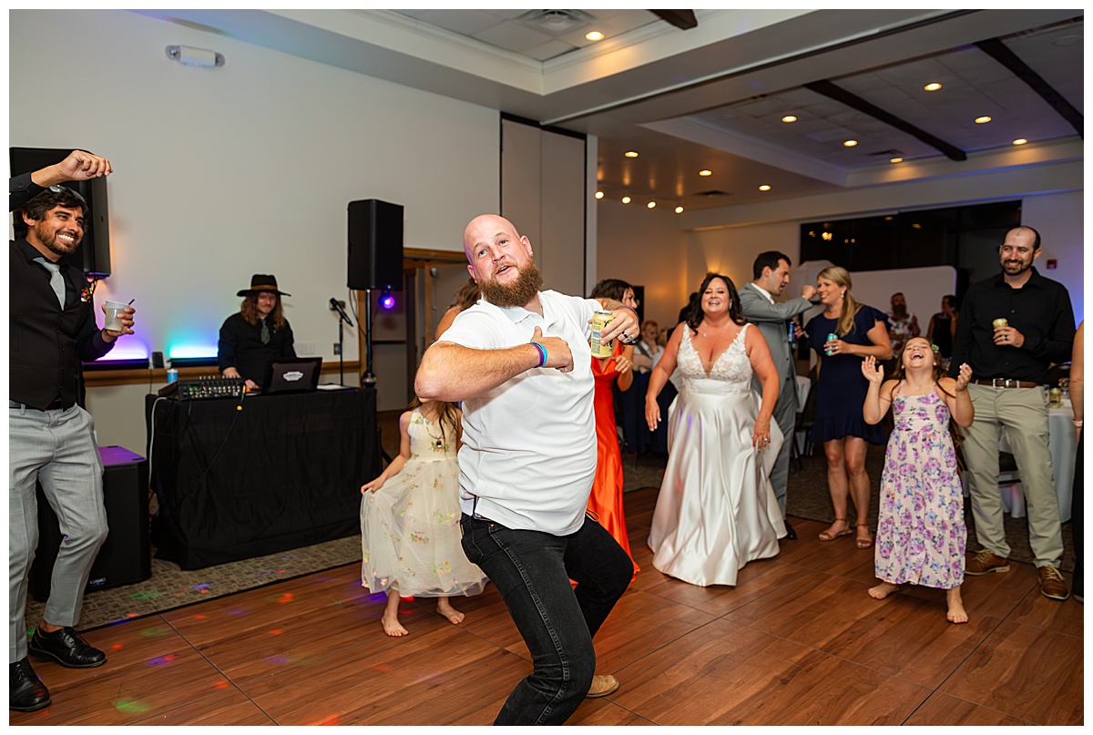 The couple dances the night away with their friends in the ballroom of the Winter Park Mountain Lodge. The dace floor is full and people are signing and dancing.