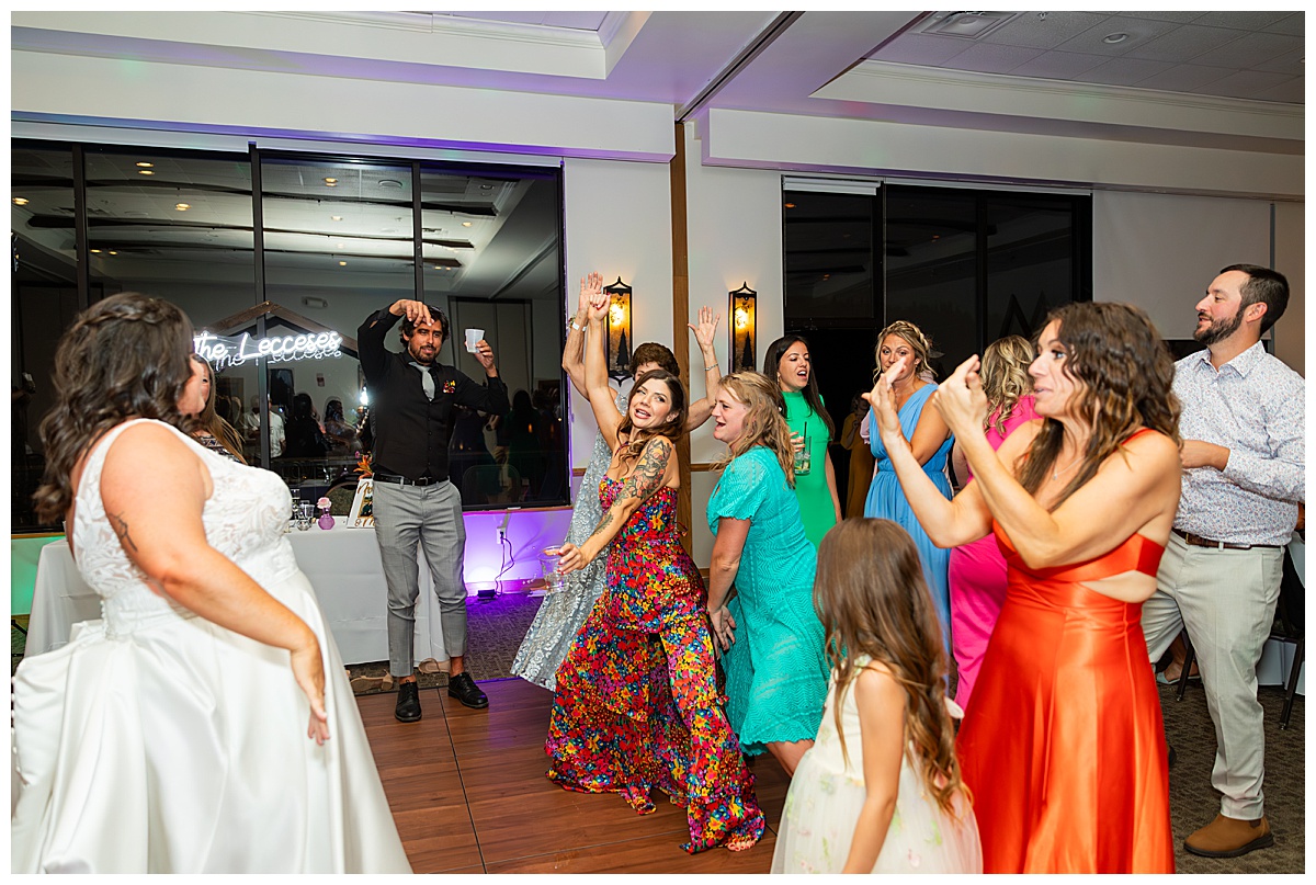 The couple dances the night away with their friends in the ballroom of the Winter Park Mountain Lodge. The dace floor is full and people are signing and dancing.