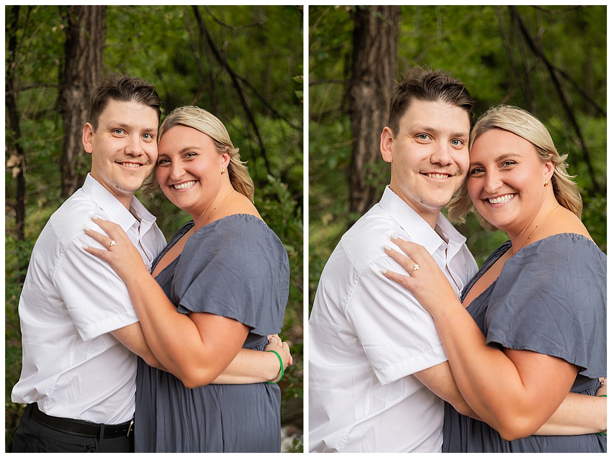 The couple celebrates after the proposal. He is wearing black slacks and a short sleeve, white button-down. She has short blonde hair and is wearing a long blue dress. There are green trees and a river in the background.