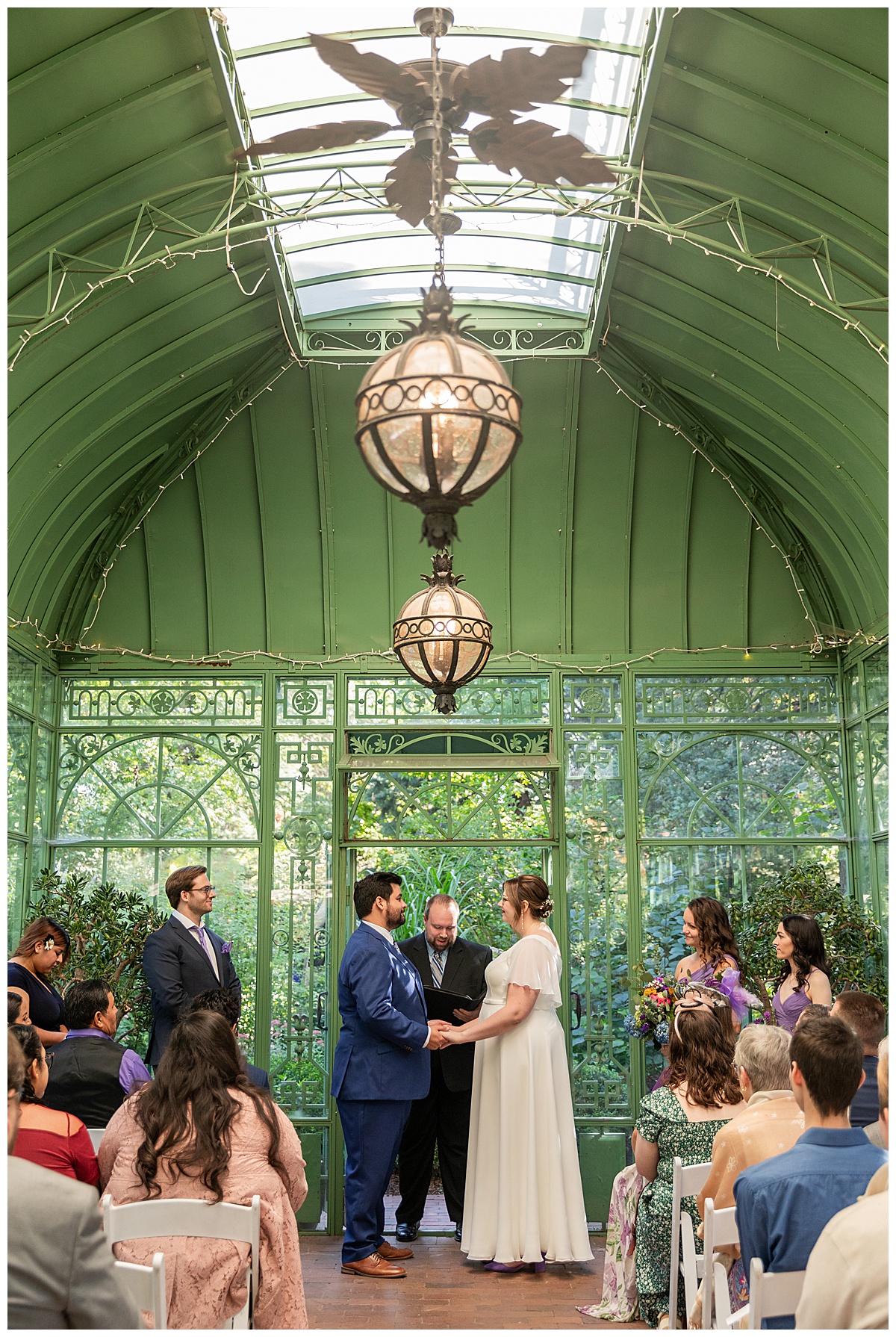 The bride and groom have their ceremony in the green metal Woodland Mosaic Solarium at their Denver Botanic Gardens wedding.