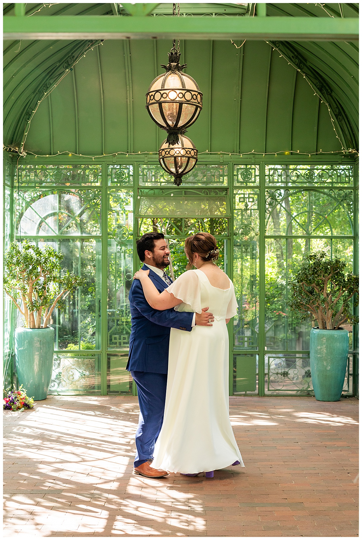 The bride and groom dance inside the green metal Woodland Mosaic Solarium. The solarium is empty now.