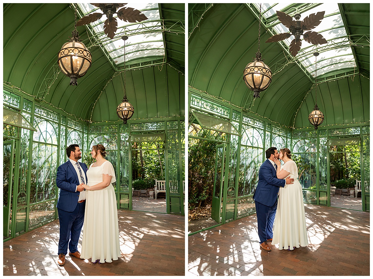 The bride and groom pose inside the green metal Woodland Mosaic Solarium. The solarium is empty now.