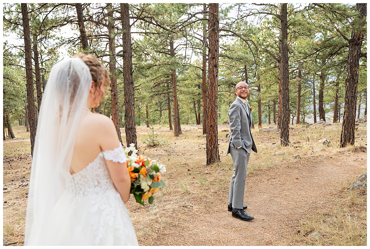 Photos of the bride and groom doing their first look for their Lookout Mountain wedding. They are standing in a pine forest.