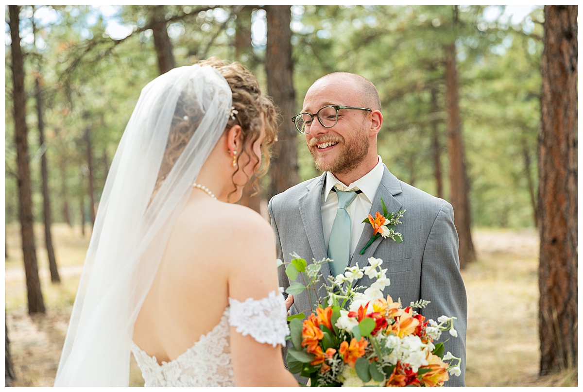 Photos of the bride and groom doing their first look for their Lookout Mountain wedding. They are standing in a pine forest.