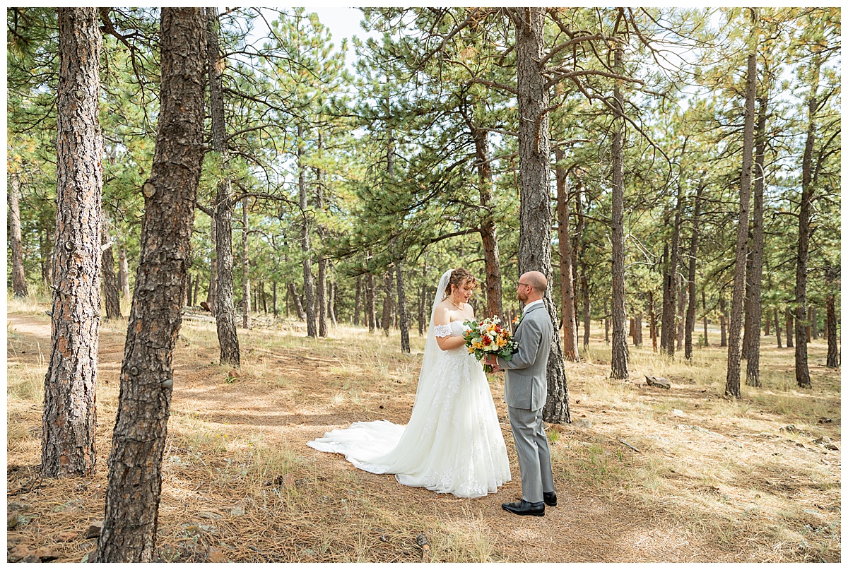 Photos of the bride and groom doing their first look for their Lookout Mountain wedding. They are standing in a pine forest.