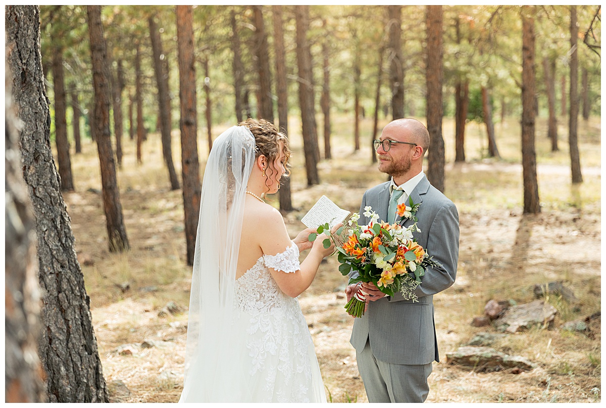 Photos of the bride and groom doing their first look for their Lookout Mountain wedding. They are standing in a pine forest.