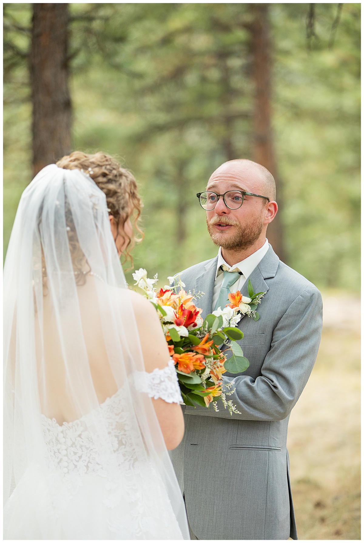 Photos of the bride and groom doing their first look for their Lookout Mountain wedding. They are standing in a pine forest.