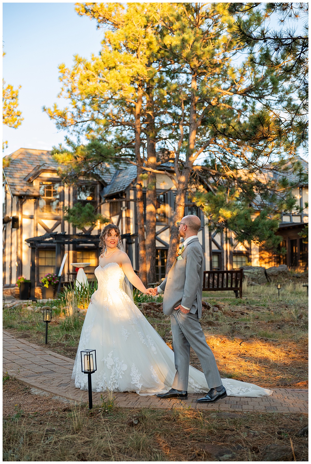 Golden hour photos of the bride and groom just outside Boettcher Mansion. They are posing in a forest of pine trees with golden light behind them.