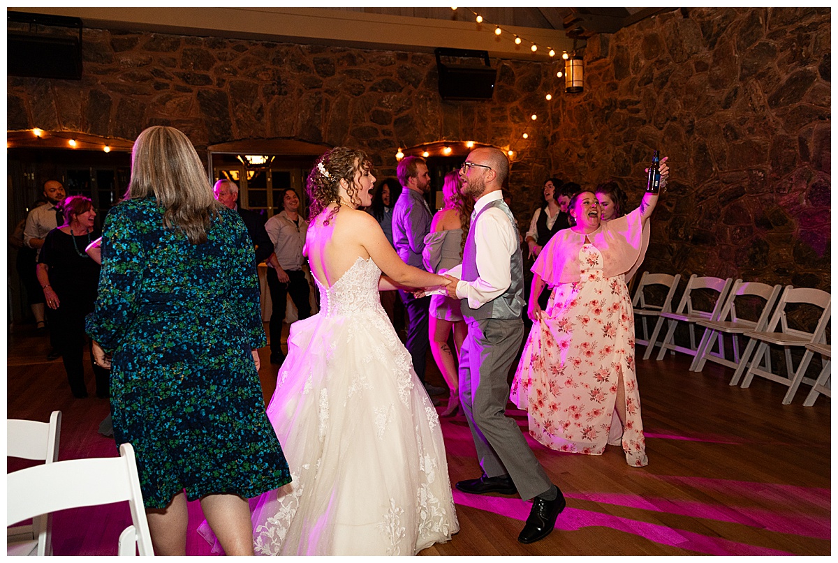 The bride and groom dance with their friends and family inside the mansion.
